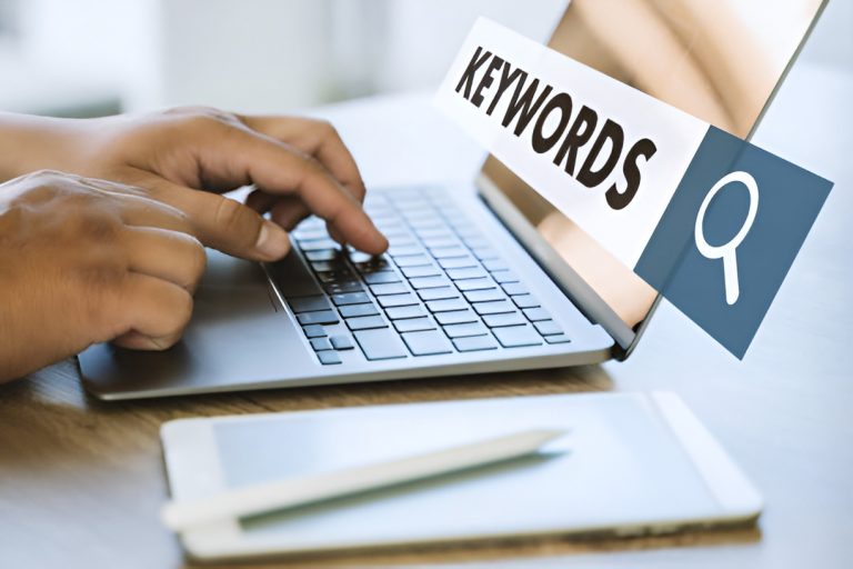 man typing on a laptop with 'keywords' text in the search bar